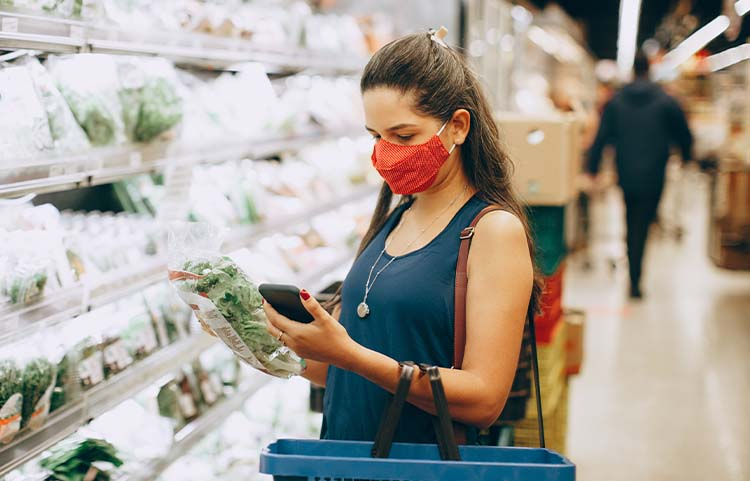 Woman looking at prices at grocery store.